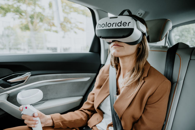 Photo of a women wearing a VR headset in the back of a car