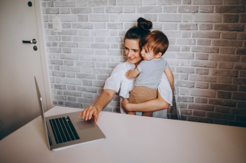 Hình ảnh một người phụ nữ với đứa con của mình trước máy tính xách tay