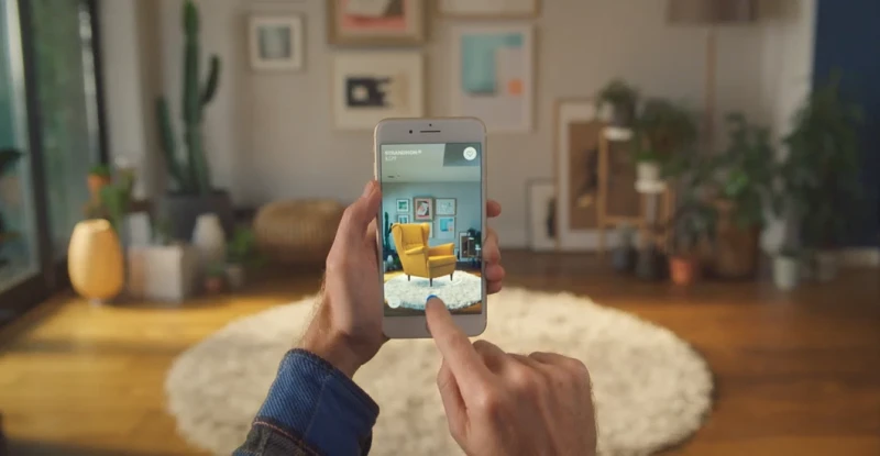 Man Uses Ikea Place App to view a yellow armchair