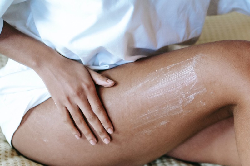 Image of a woman putting lotion on her leg [Article Image]