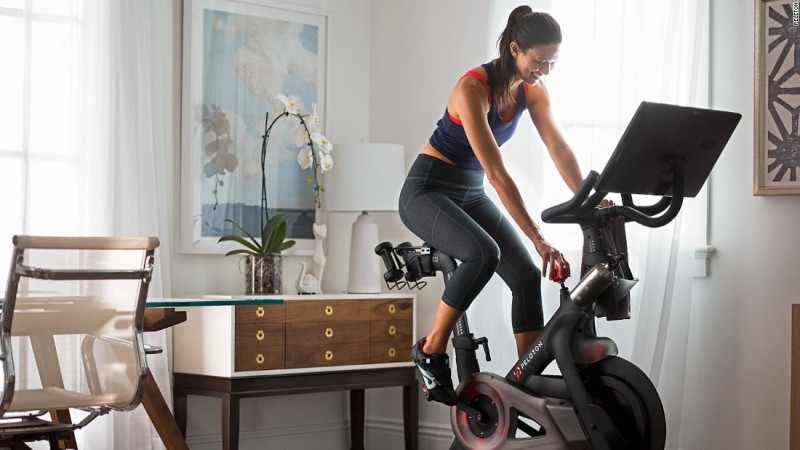 Woman on Peloton bike in living room