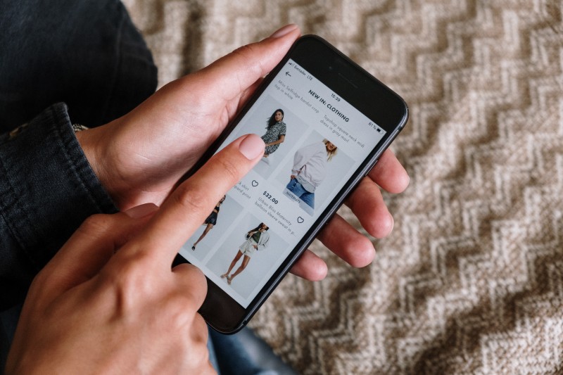Image of a person shopping on their phone (Article Iamge)