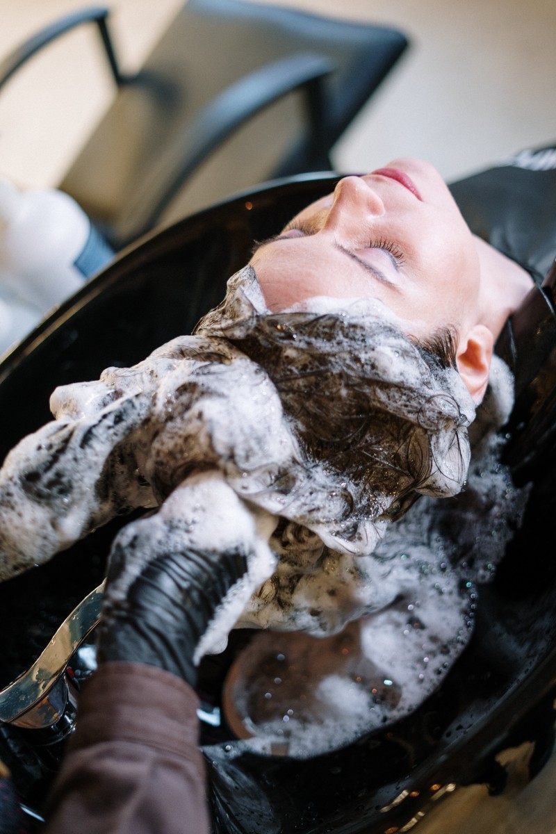 Woman having her hair washed in a sink at a hair salon