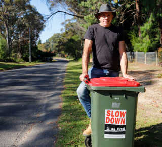 Blue mountains resident Lou Pravdacich is displaying the Slow Down In My Street sticker on his bin.