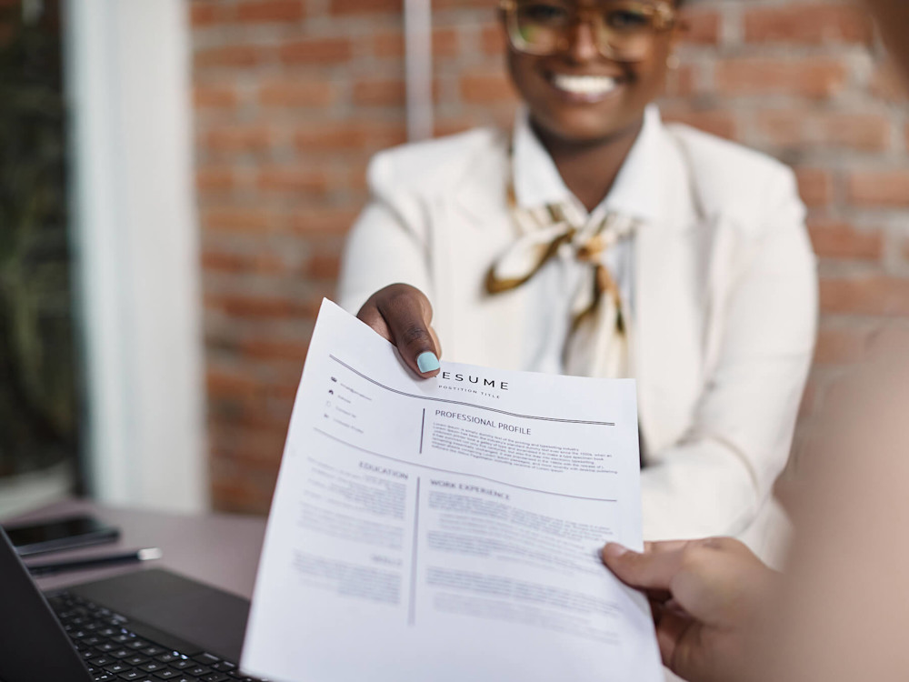 A woman is handed a resume