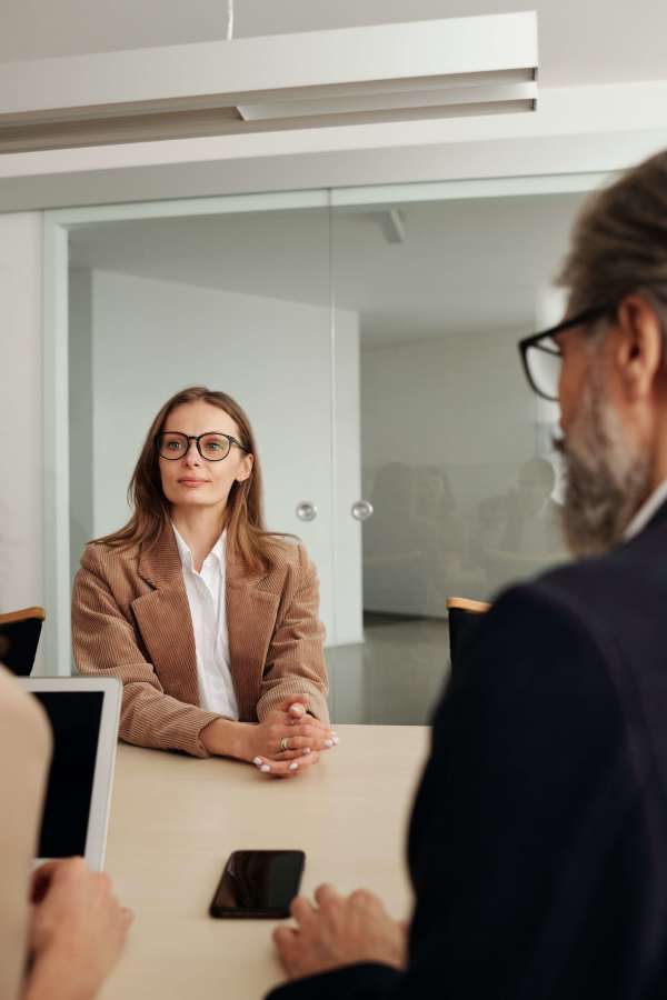 Man interviewing woman from across a large table.