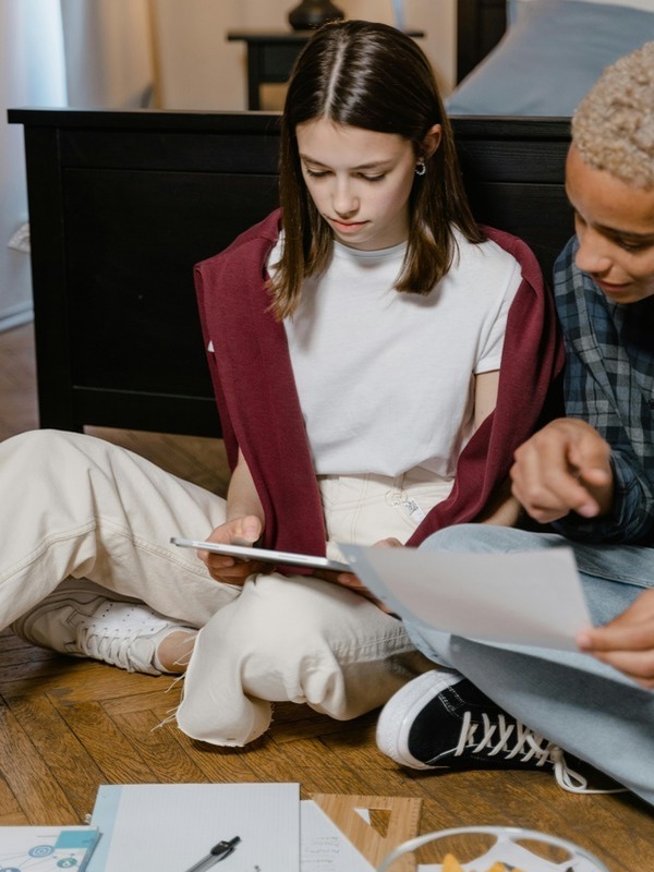 A young person and an older man reading a book together