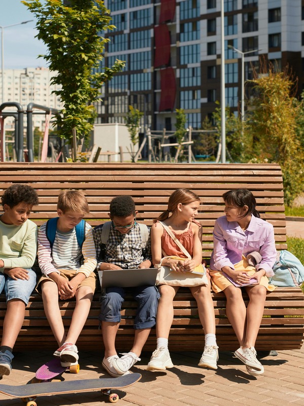 5 young people sitting on a bench and chatting