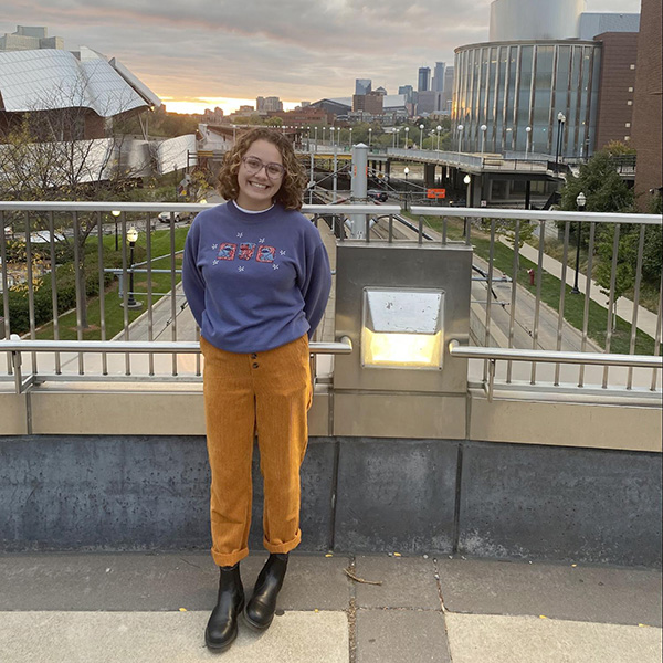 A person standing on the University of Minnesota campus smiling