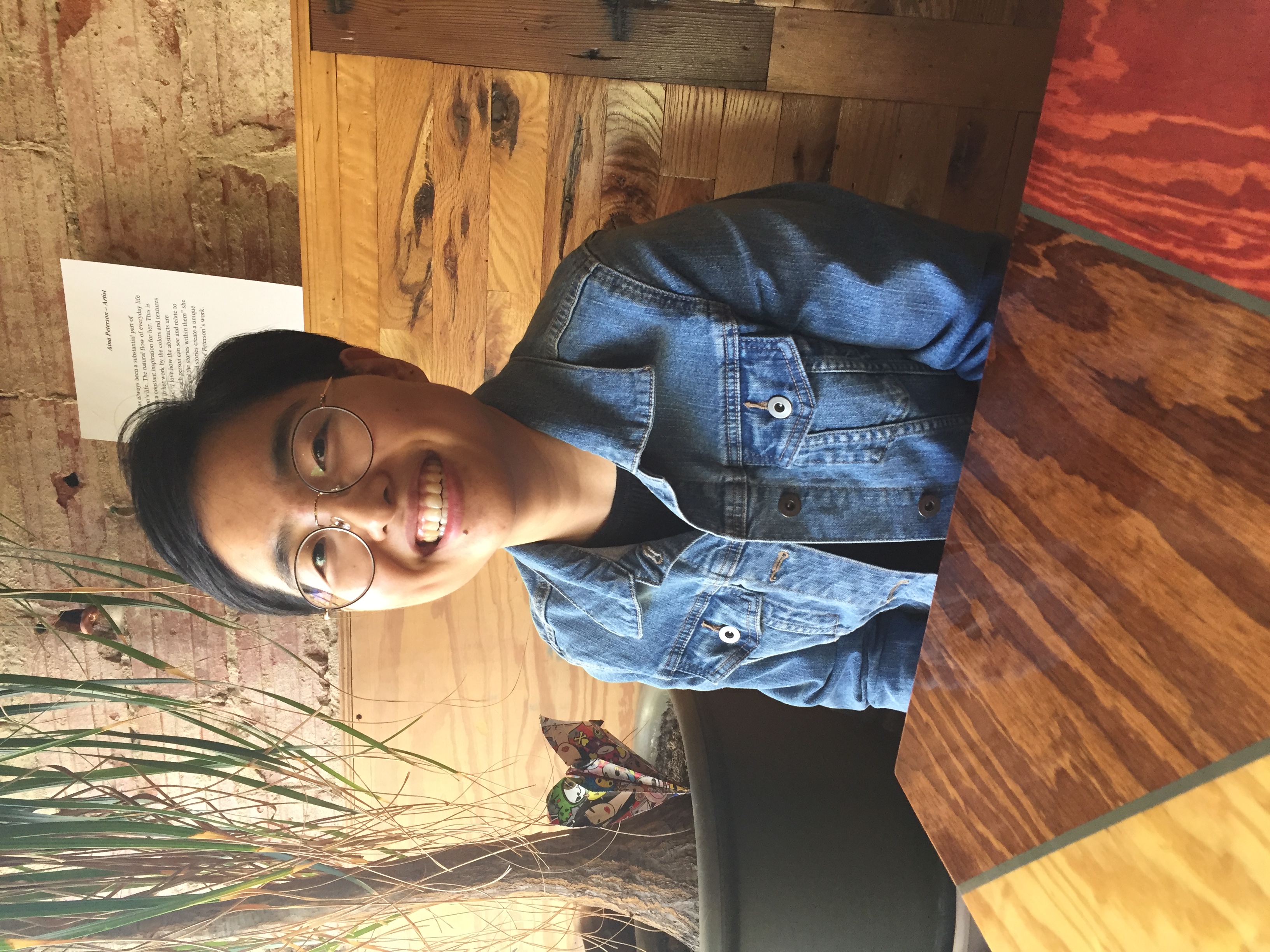 Erica Lee's headshot - a person smiling wearing glasses and a jean jacket