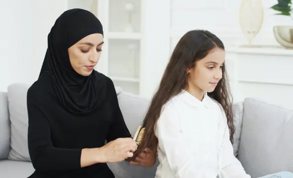 Mom Brushing Daughter's Hair