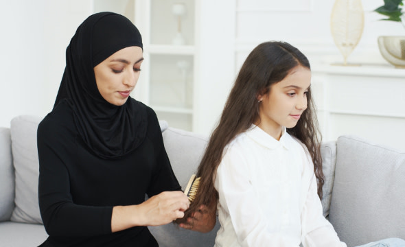 Mom Brushing Daughter's Hair