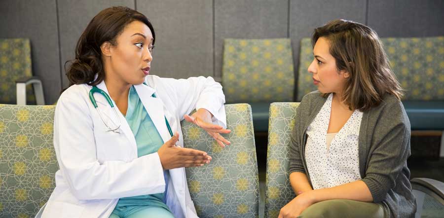 Médecin discutant avec une patiente dans une salle d’attente 