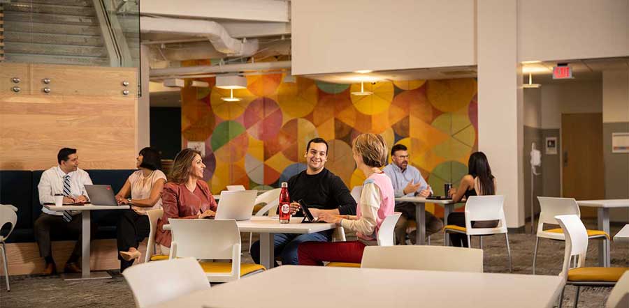 Multiple groups of people meeting in an open office area