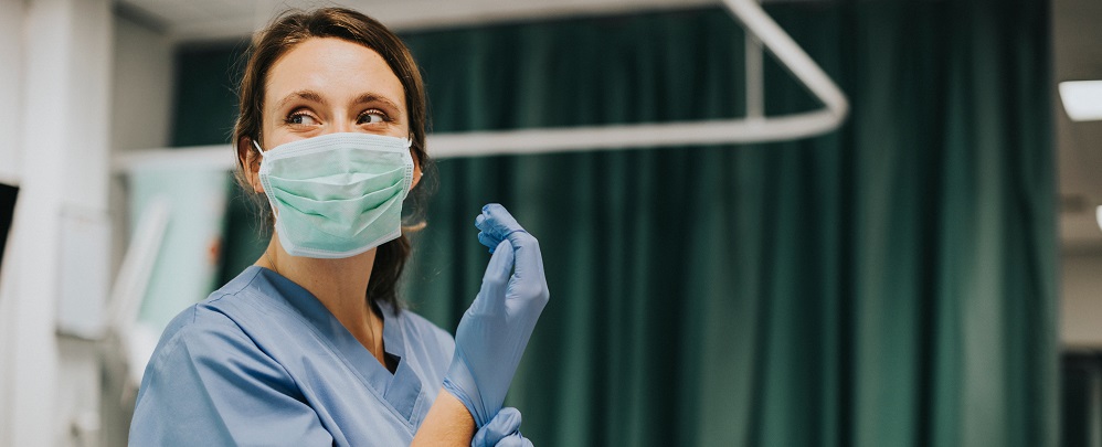 Un médecin portant un masque et des gants dans la salle d'urgence