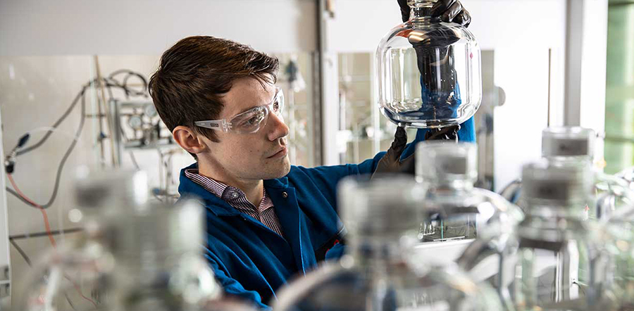Scientist looking at glass jar