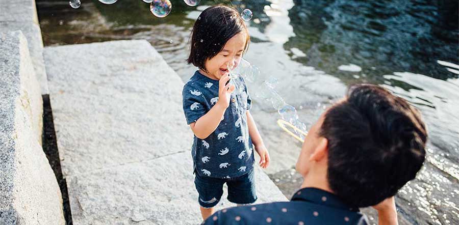 Father and young son blowing bubbles together