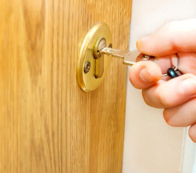 Freepik - Locking up or unlocking door with key in hand