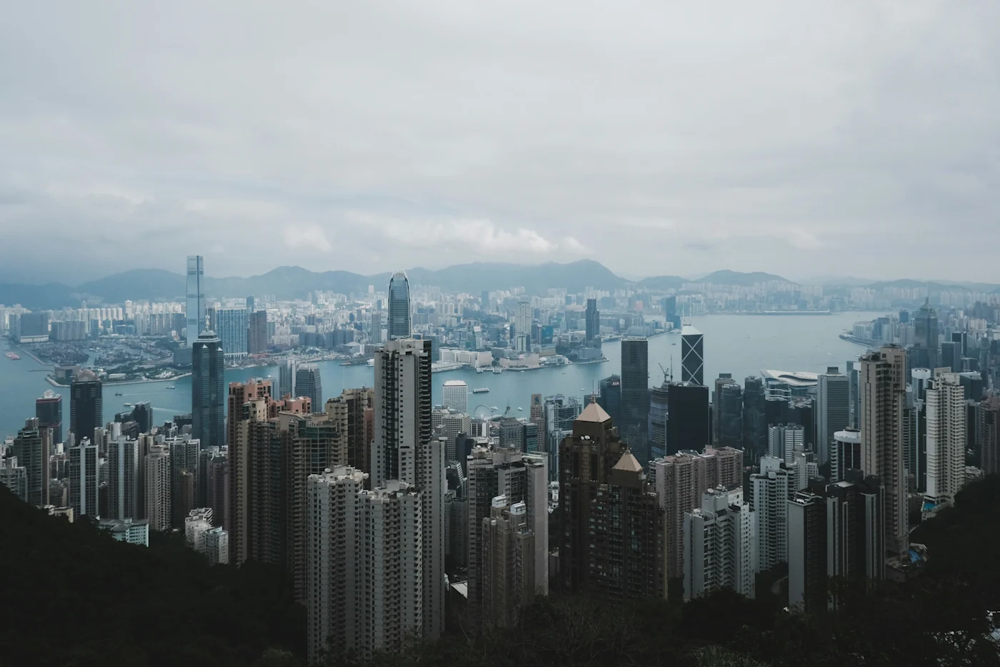 Hong Kong skyline and Victoria Harbour viewed from Victoria Peak under overcast skies.
