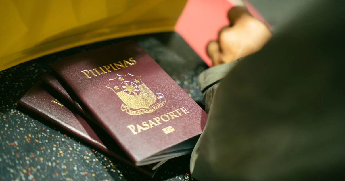 Close-up of passports and travel documents held at an airport immigration counter.