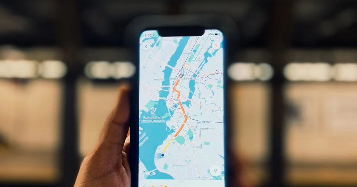 A hand holds a smartphone showing a city transit map inside a station.  (source: https://images.pexels.com/photos/14629408/pexels-photo-14629408.jpeg)