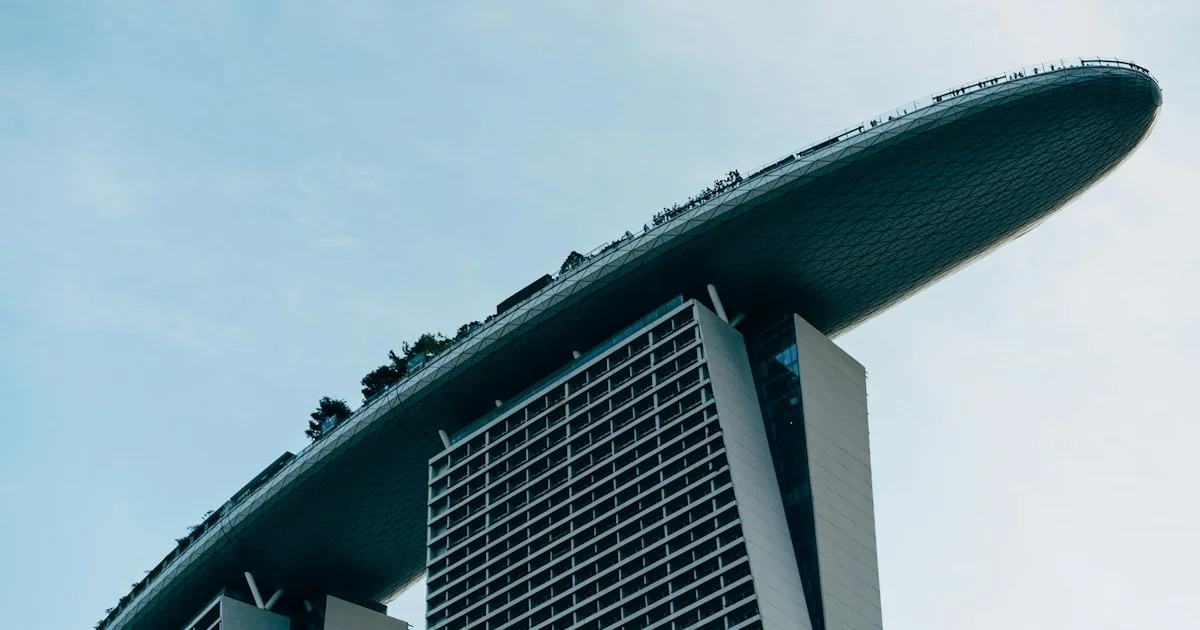 Marina Bay Sands hotel towers rising against Singapore's business-district sky.  (source: https://images.unsplash.com/photo-1744705221117-9c726f9497b0)