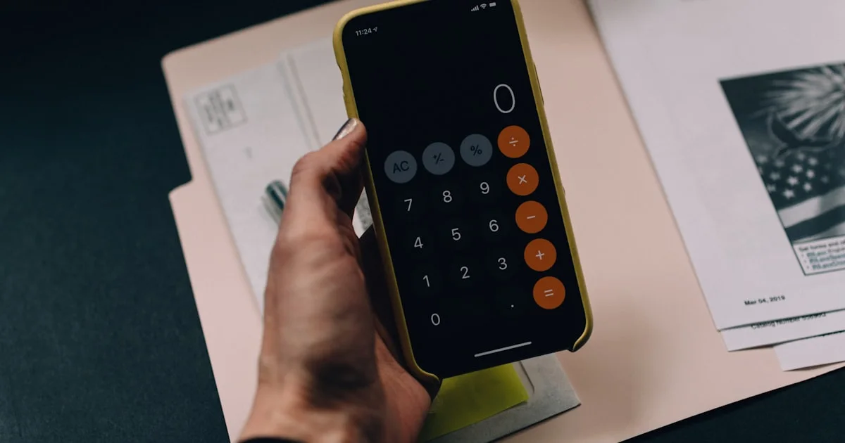 A person reviewing financial figures and a payment card at a desk.  (source: https://images.unsplash.com/photo-1554224155-8d04cb21cd6c)