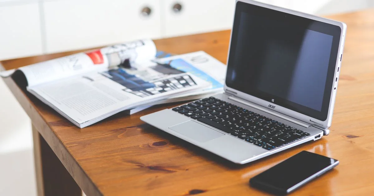 A laptop and smartphone arranged neatly on a warm wooden home-office desk.  (source: https://images.pexels.com/photos/6351/smartphone-desk-laptop-technology.jpg)