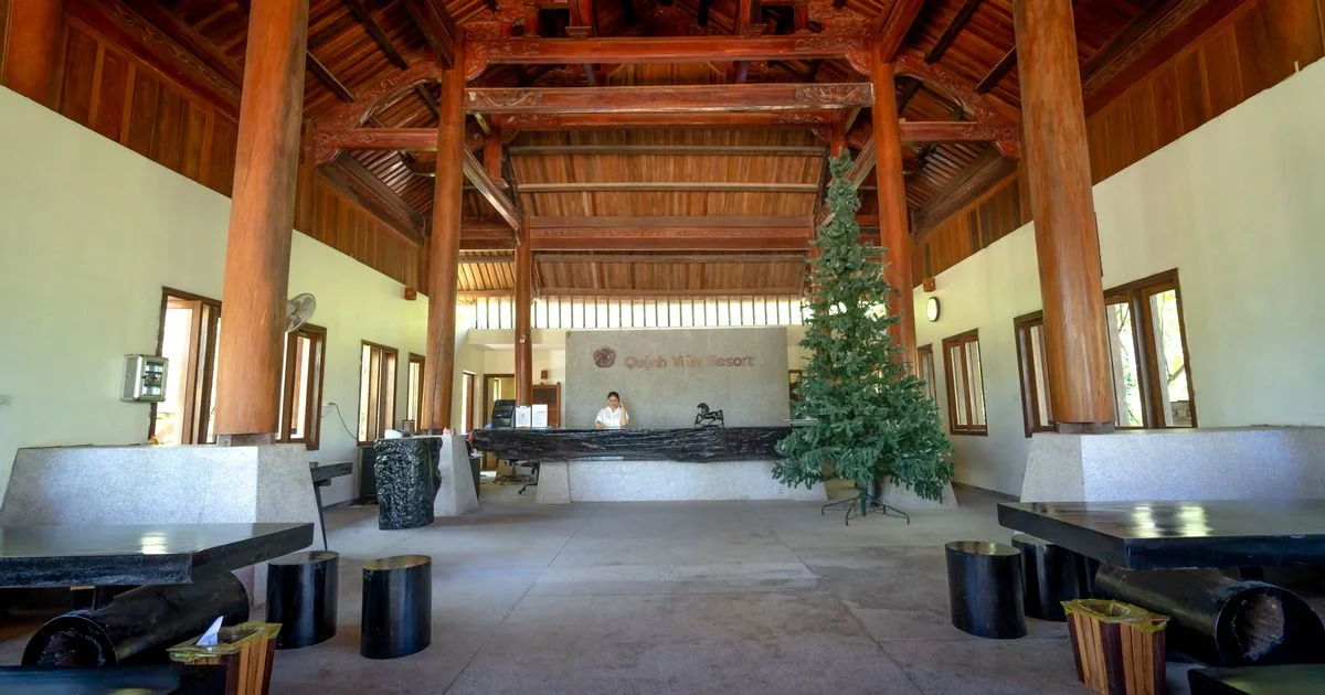 Hotel lobby with a reception desk under a vaulted timber ceiling.