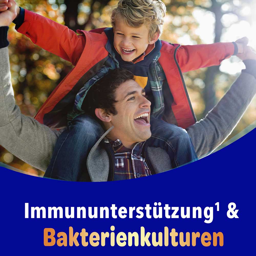 Vater hebt lachenden Sohn in die Luft im Herbstpark, mit dem Text „Immununterstützung & Bakterienkulturen"