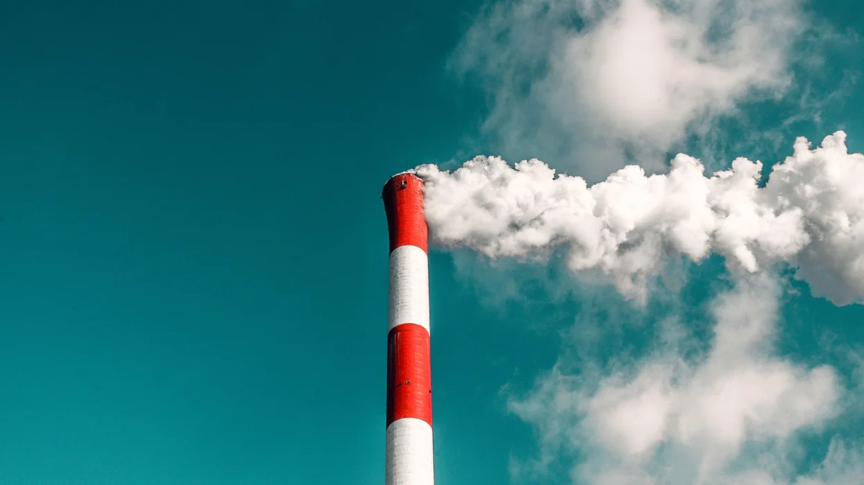 a-red-and-white-smokestack-against-a-blue-sky