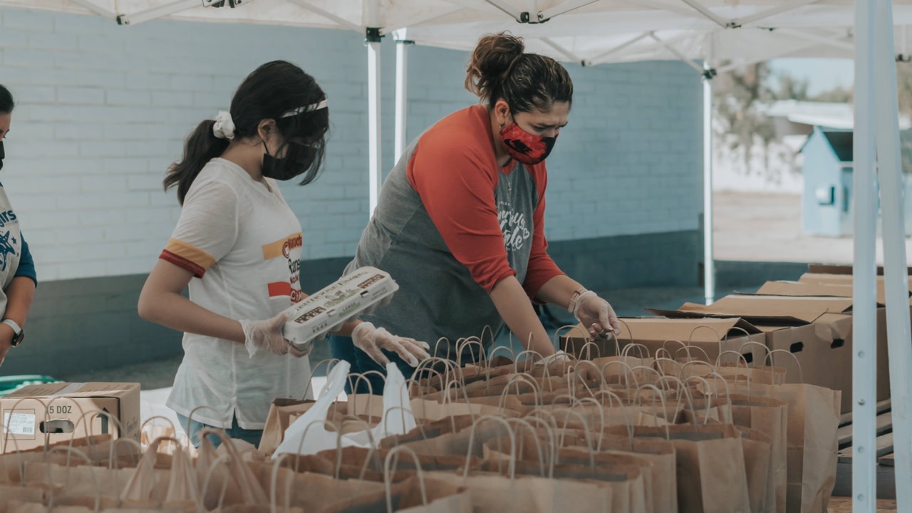 Image of volunteers filling paper bags with supplies