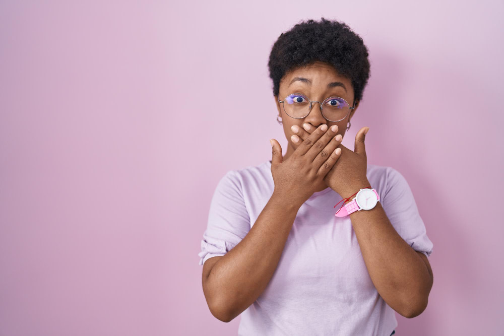 Image of young-african-american-woman-standing-pink-background-shocked-covering-mouth-with-hands-mistake-secret-concept