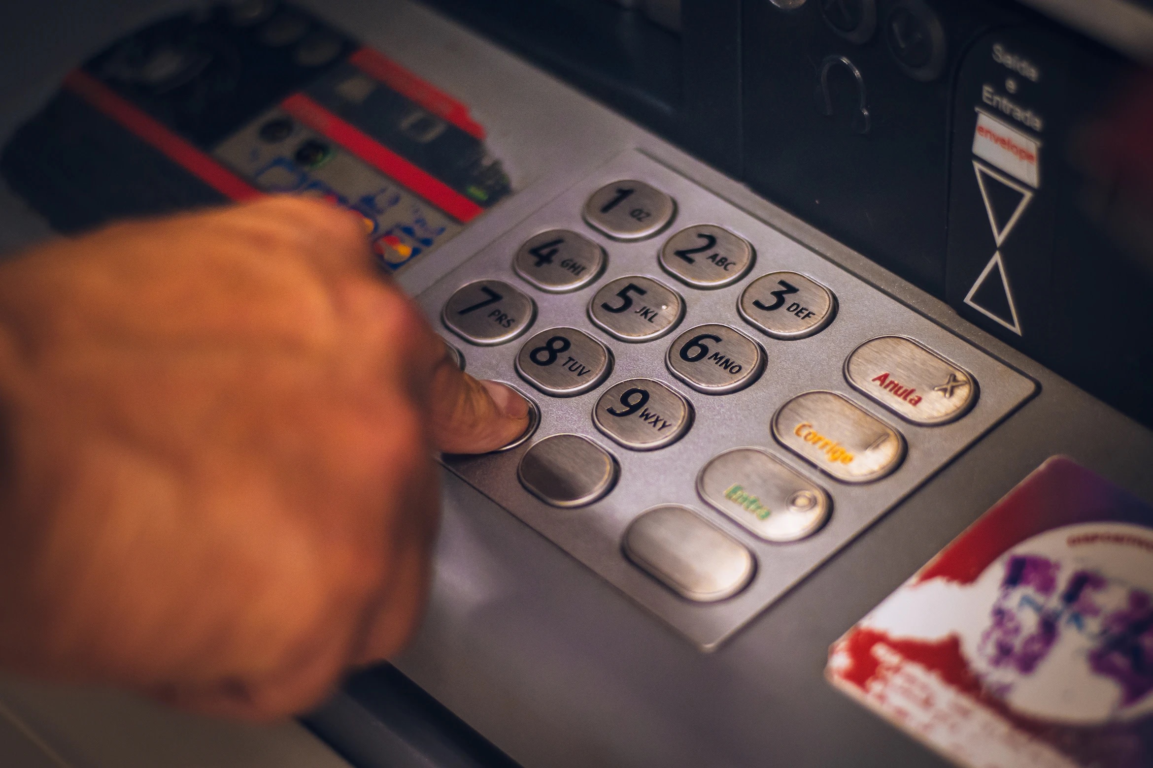 Image of ATM console with buttons being pressed by hand