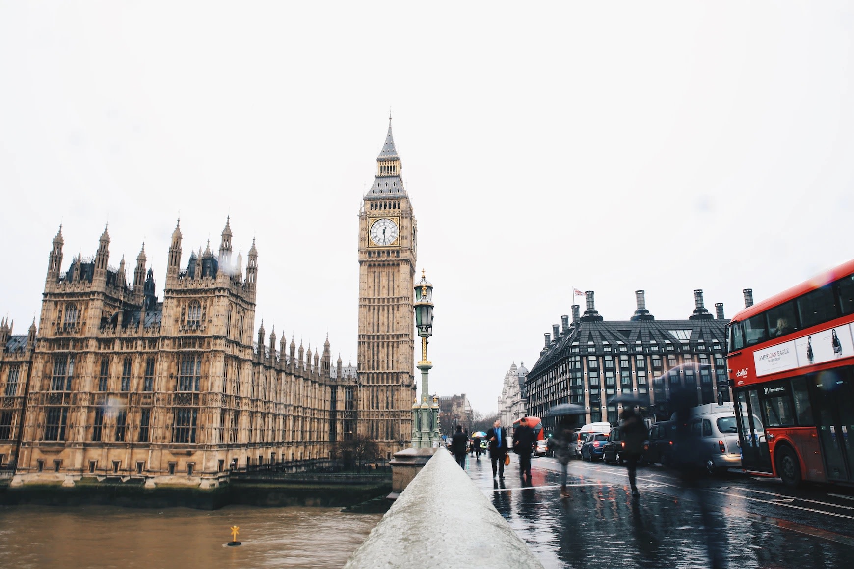 Image of pedestrians and traffic in rain on Westminster Bridge, with Big Ben and the Houses of Parliament in view.