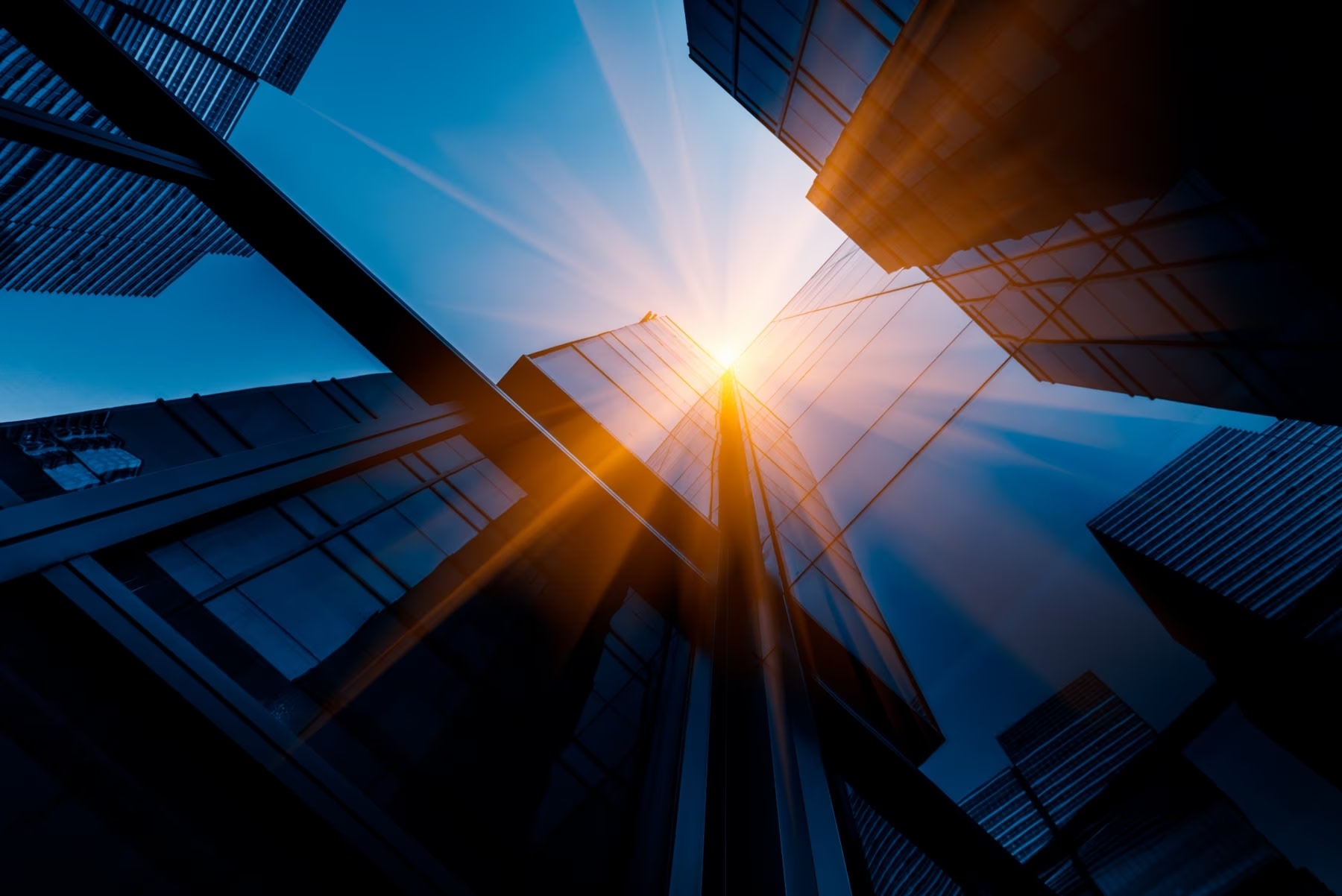 Low angle view up of finance sector skyscrapers with blue sky and sunlight