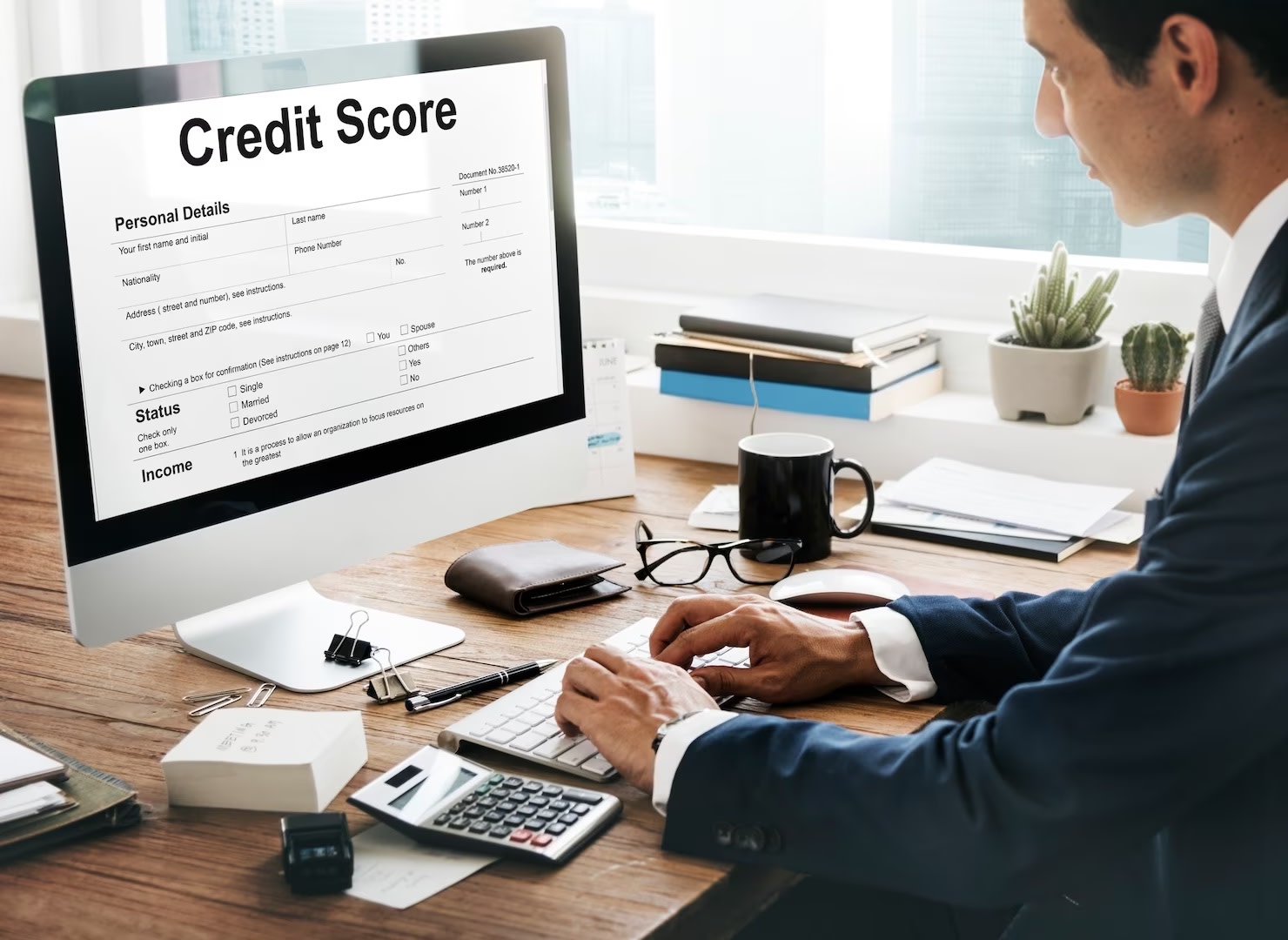 Man sitting at desk checking credit score on screen