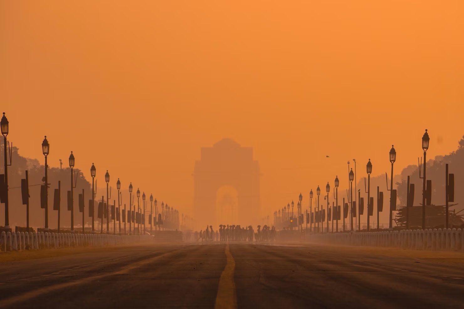 Image of morning view of road leading to India Gate in New Delhi with orange polluted skies