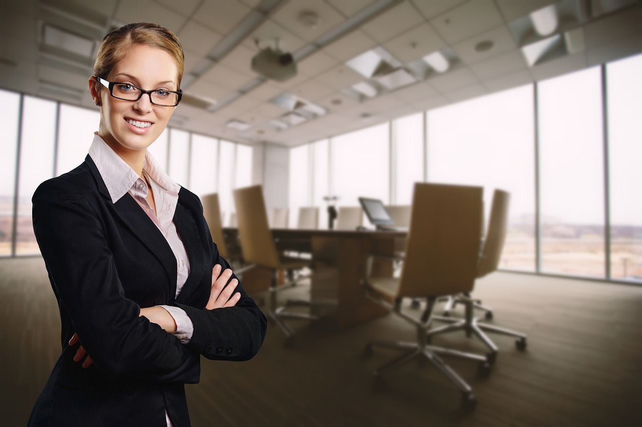 Image of white businesswoman with folded arms in boardroom setting
