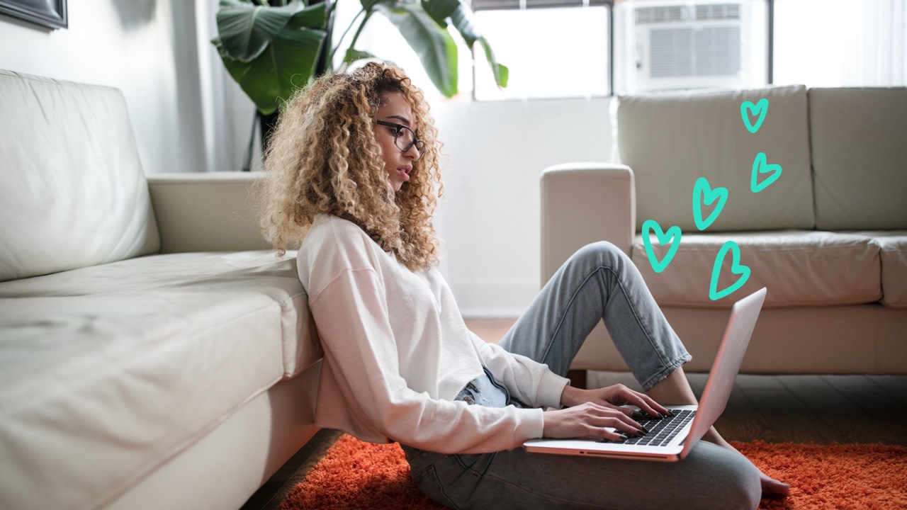 Image of woman sitting on floor with laptop, with Matchable hearts 