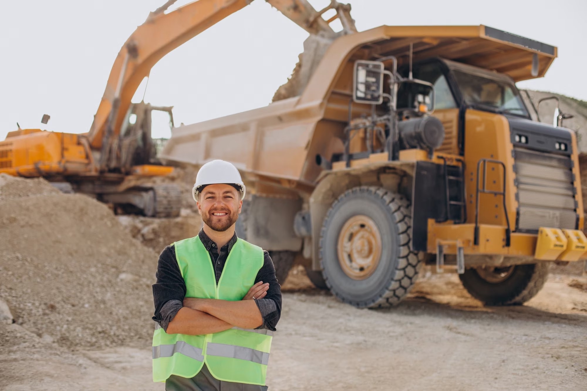 Image of male mine worker in front of bulldozer at quarry