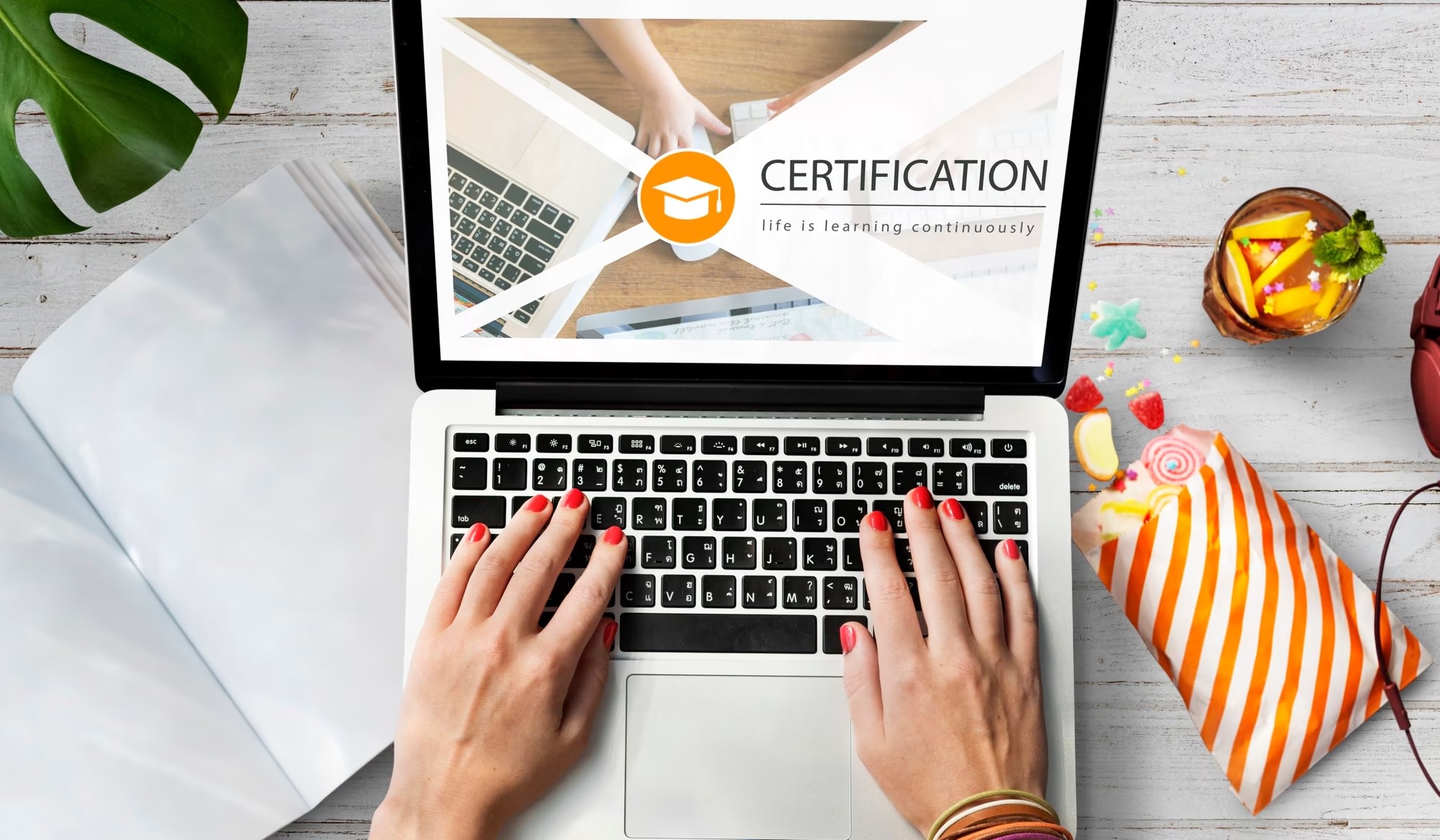 Image of hands typing on laptop with certification info on screen