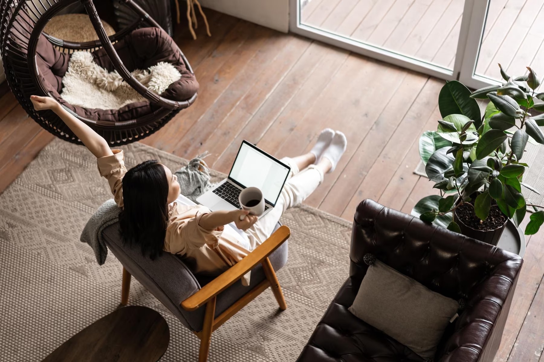 Happy Asian woman sitting at home working on laptop