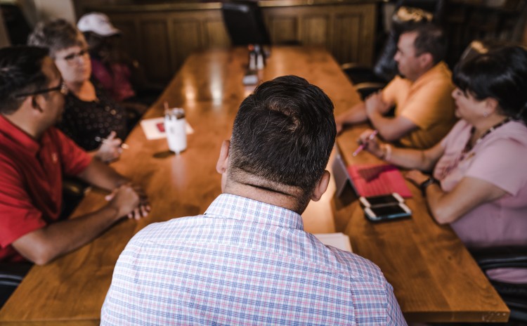 Image of boardroom table with colleagues of multiple ethnicity in discussion