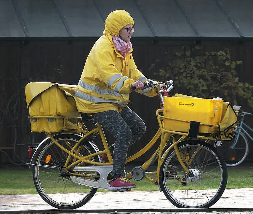 A Deutsche Post's employee carrying parcels and mails