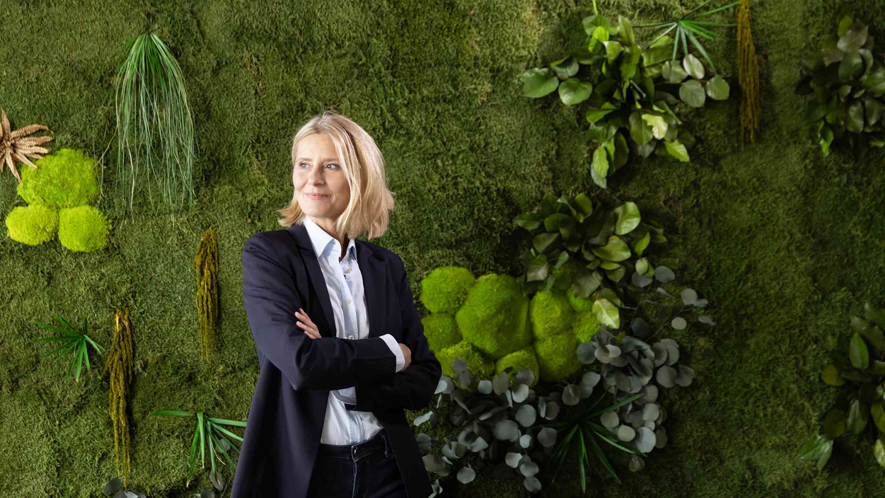 Mature-female-professional-standing-with-arms-crossed-in-front-of-plants