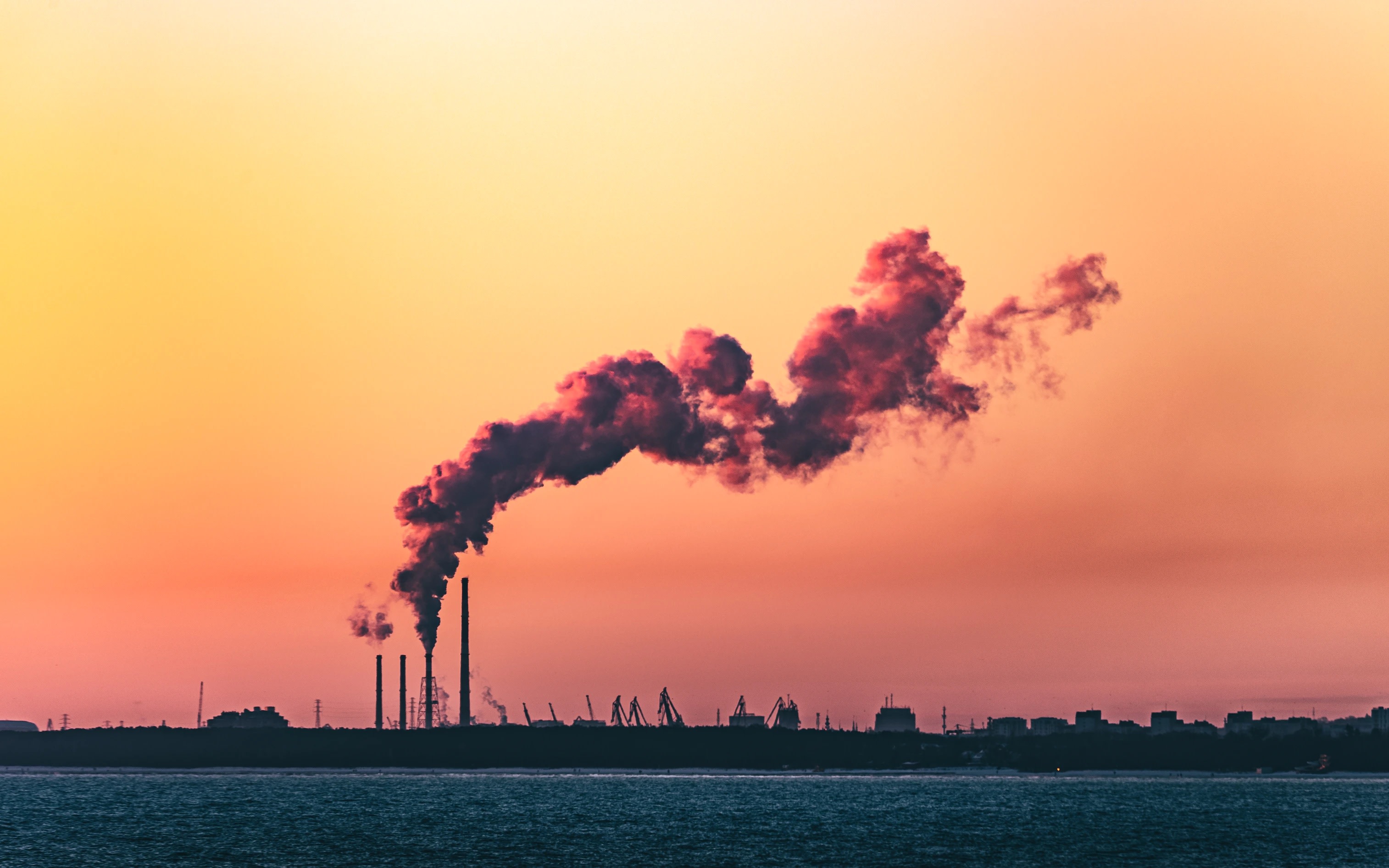 Dusk image of smoke billowing from oil refinery in  Gdańsk, Poland