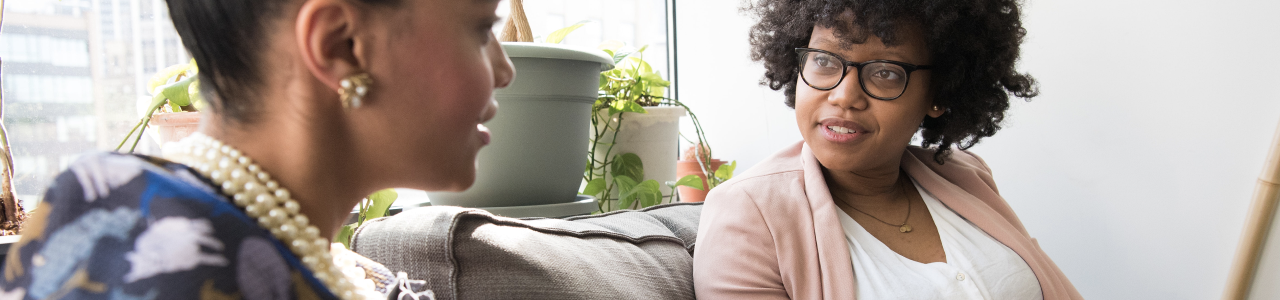 Two women speaking on couch 