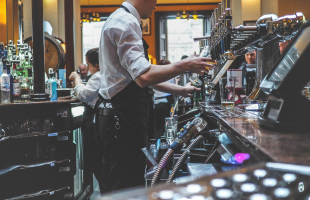 bar man in bar pulling pints of beer