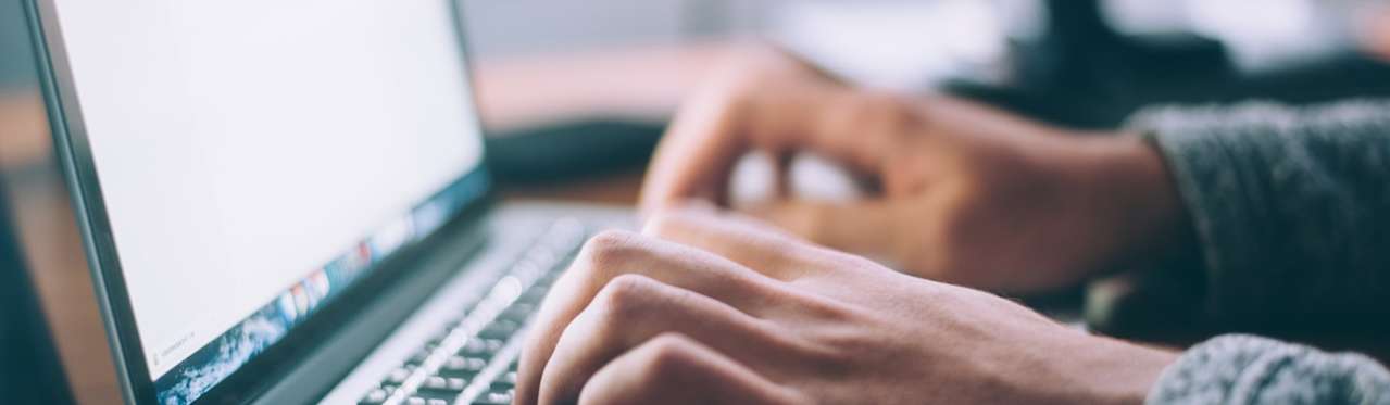 man typing on laptop at desk
